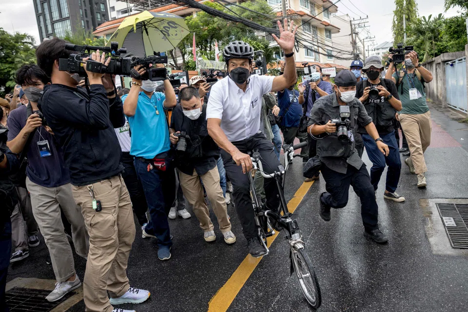 Independent candidate Chadchart Sittipunt (in white shirt) leaves after casting his vote in the governor elections in Bangkok on May 22, 2022. 