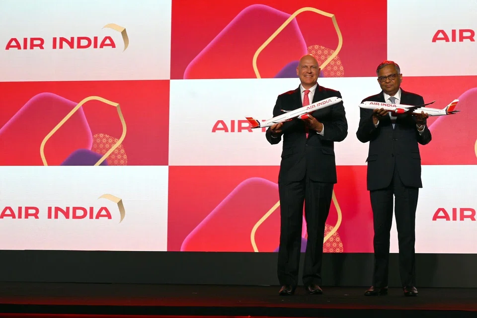 Air India's CEO Campbell Wilson and chairman Natarajan Chandrasekaran hold model aircrafts during the unveiling event for the carrier’s rebranded look.