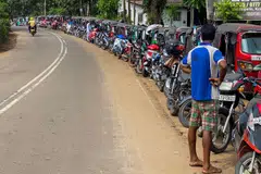 Motorists queue along a street to buy fuel at a Ceylon petroleum corporation fuel station in Pugoda, some 50 km from Colombo.  The island nation of 22 million people has been suffering dire shortages of many essentials due to a lack of foreign currency.
