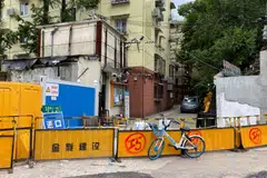 A shared bike is placed next to barricades blocking a residential compound amid the Covid-19 outbreak in Shanghai, China, May 15, 2022.