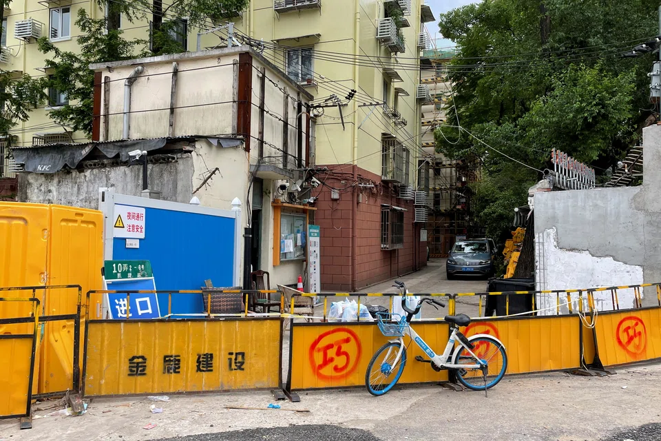 A shared bike is placed next to barricades blocking a residential compound amid the Covid-19 outbreak in Shanghai, China, May 15, 2022.