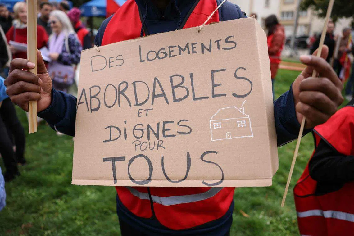 A protestor holds a placard which reads "affordable and decent housing for everyone" at a recent event last month. The sky-high cost of buying or renting a home in Luxembourg has made living there nearly impossible for some.