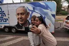 A camper wagon with electoral banner depicting Benjamin Netanyahu, who has focused his message on high living costs – a top concern for voters – and dismissing his trial as “rigged” and “a joke”.
