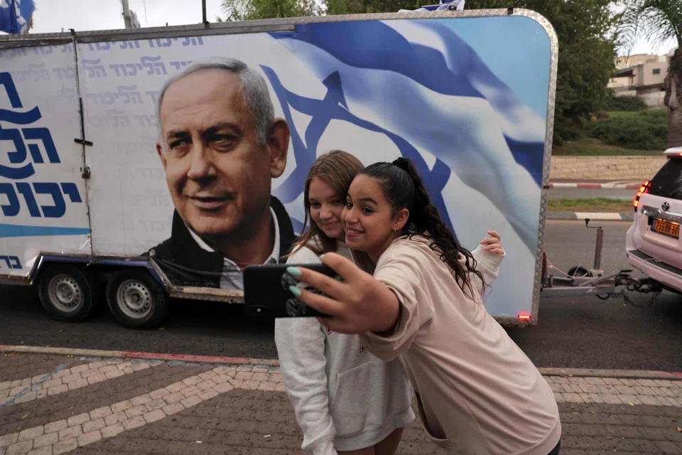 A camper wagon with electoral banner depicting Benjamin Netanyahu, who has focused his message on high living costs – a top concern for voters – and dismissing his trial as “rigged” and “a joke”.