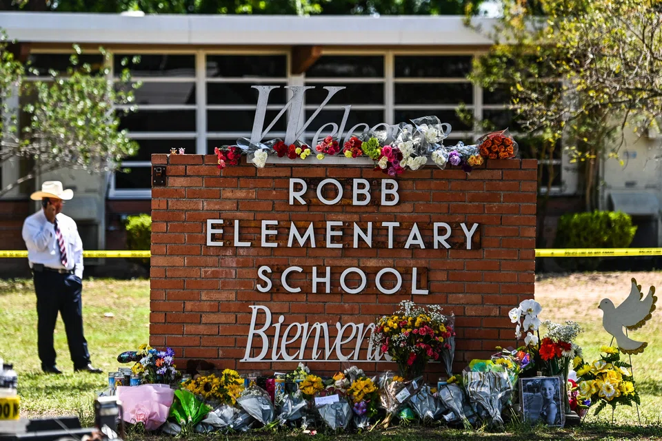 Flowers are placed on a makeshift memorial in front of Robb Elementary School in Uvalde, Texas, on May 25, 2022. - The tight-knit Latino community of Uvalde was wracked with grief Wednesday after a teen in body armor marched into the school and killed 19 children and two teachers, in the latest spasm of deadly gun violence in the US. (Photo by CHANDAN KHANNA / AFP)