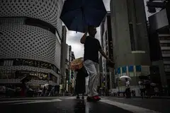 Pedestrians walk with their umbrellas in the rain in Ginza district of Tokyo on Aug 13, 2023, as Typhoon Lan heads for Japan's main island Honshu. 