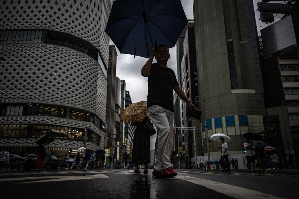 Pedestrians walk with their umbrellas in the rain in Ginza district of Tokyo on Aug 13, 2023, as Typhoon Lan heads for Japan's main island Honshu. 