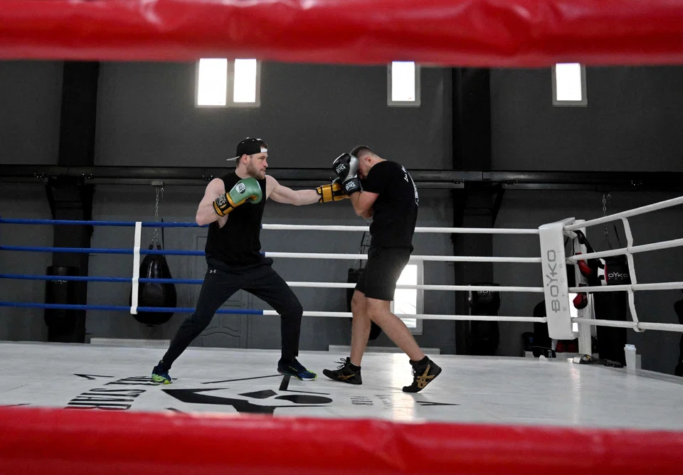 Amateur boxers train at the All Stars Boxing Club in the Ukrainian capital of Kyiv on May 10, 2022. - The sound of hip hop mixes with the dull thuds of fists walloping heavy bags, as a group of boxers unleash combinations and burn off weeks of pent up stress in the Ukrainian capital. (Photo by Sergei SUPINSKY / AFP)