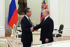 Russian President Vladimir Putin shakes hands with China's top diplomat Wang Yi during their meeting in the Kremlin on 22 Feb 2023. 