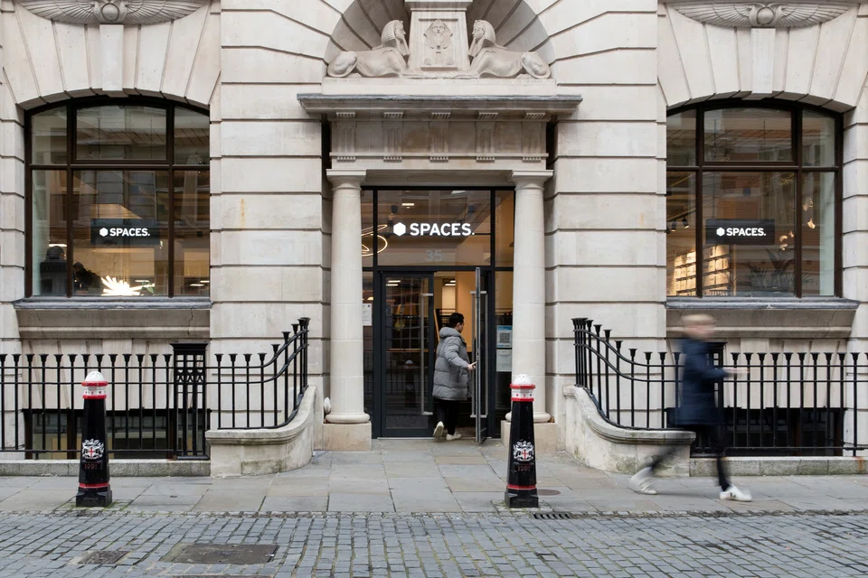 FILE PHOTO: A person enters a Spaces office workspace, an IWG brand, in London, Britain, December 1, 2021. Picture taken December 1, 2021.   REUTERS/May James/File Photo