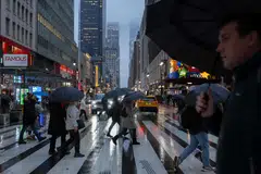 People with umbrellas walk through heavy rain in New York, Jan 9, 2024. A major storm system was battering parts of the United States on Tuesday.