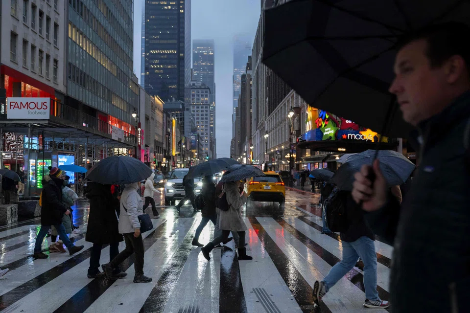 People with umbrellas walk through heavy rain in New York, Jan 9, 2024. A major storm system was battering parts of the United States on Tuesday.