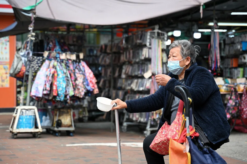 An elderly woman begs for alms in the Kowloon district of Hong Kong. By improving dozens of outcomes simultaneously, cash transfers offer a transformative solution to multidimensional poverty.