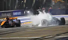 The remains of Stroll's Aston Martin, with him in the cockpit, bounced back onto the track to be narrowly avoided by the McLaren of Lando Norris.