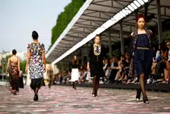 Models strode across the cobblestones lining the river, parading tweed suits lined with tufts of tulle or embellished with flower motifs in autumn tones