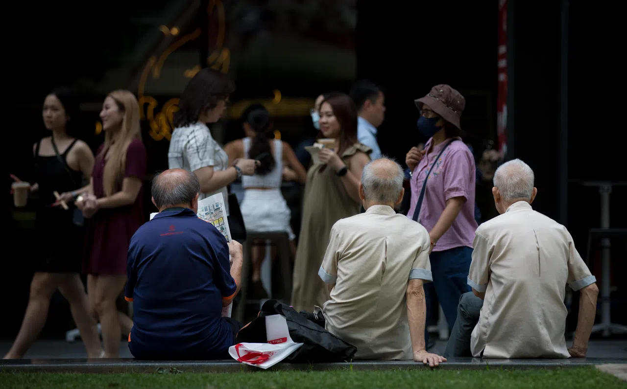 Elderly man watch office workers pass by during lunchtime in the CBD area, 5 July 2023. retirement, aging