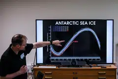 A professor of the British Antarctic Survey explaining a graph on the state of the Antarctic sea ice over the years in Cambridge in June.  
