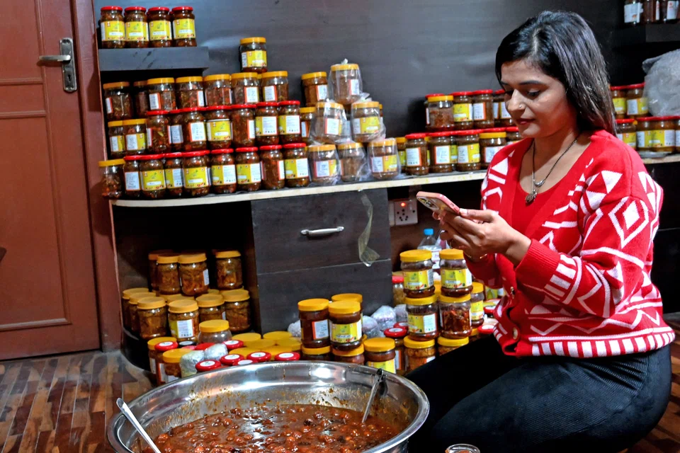 Since the ban, Anjana Aryal (above, packing pickles in her home) and other prominent Nepali content creators have seen their revenue streams dry up, jeopardising their livelihoods.
