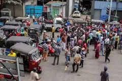 People block a road as they protest against scarcity of fuel near a fuel station in Colombo on June 24, 2022. 