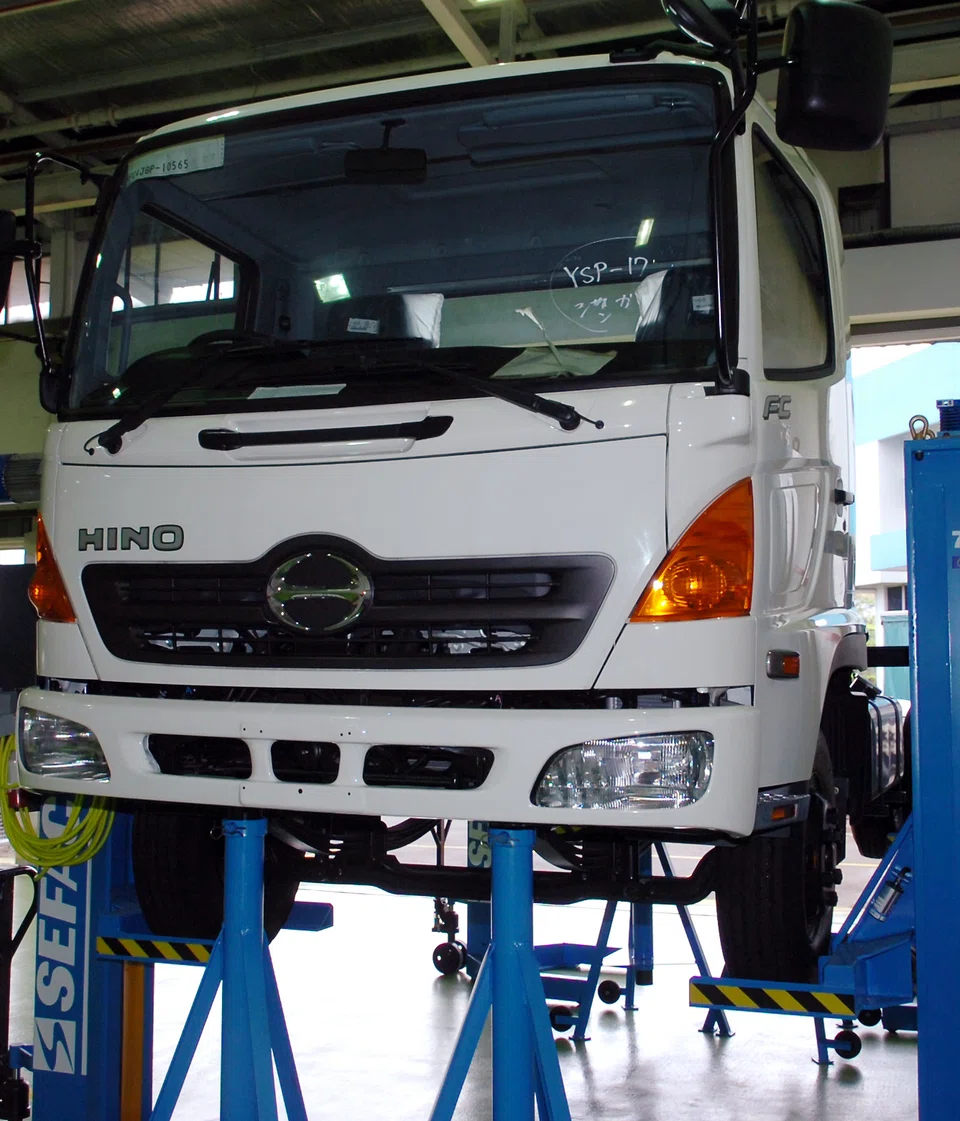 A Hino truck on a hoist.  The data falsification scandal, which came to light in March, was previously not believed to have impacted the smaller trucks, which have been sold since 2019. The Japanese truck and bus maker said in a statement that some 76,694 vehicles of its Dutro small truck model were impacted, bringing the total number of vehicles involved in the scandal to more than 640,000.