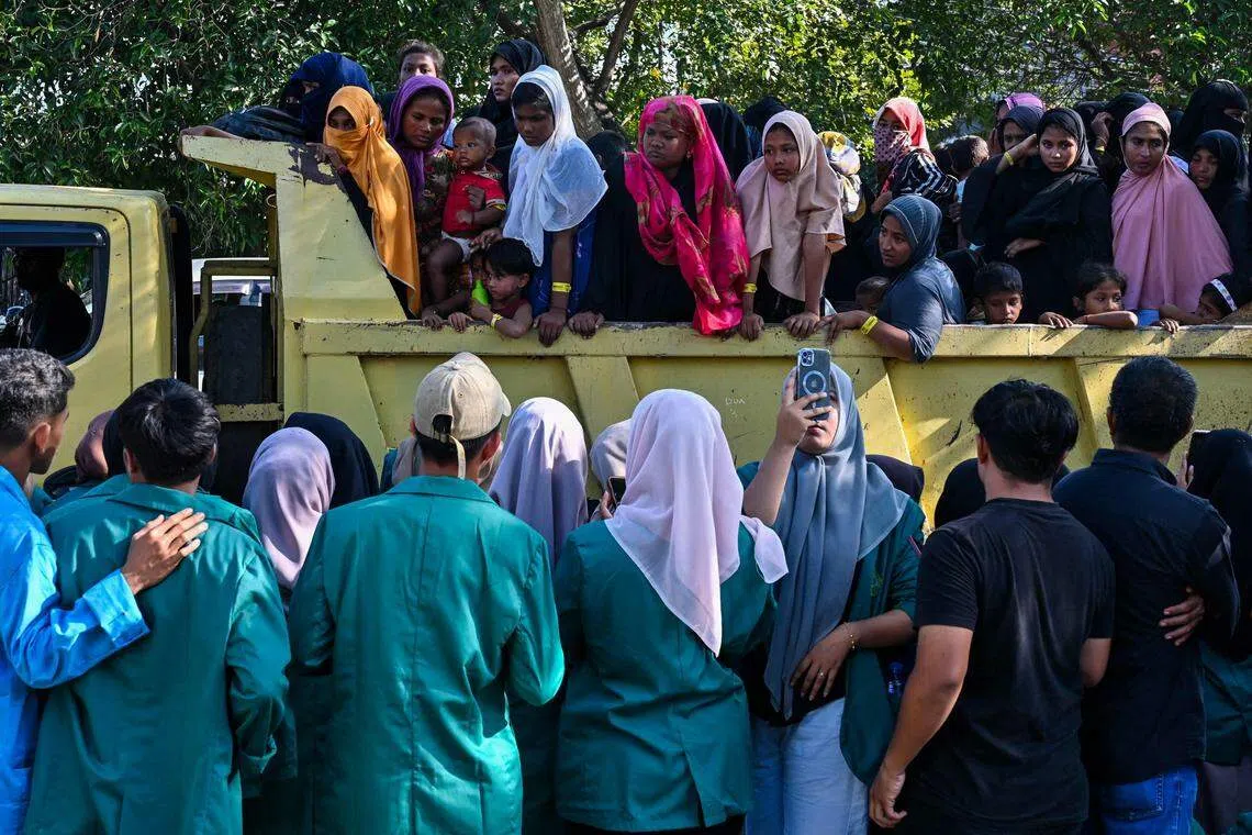 Rohingya refugees forced into a vehicle for relocation to a nearby government building after demonstrating university students forced them out of a government facility in Banda Aceh.