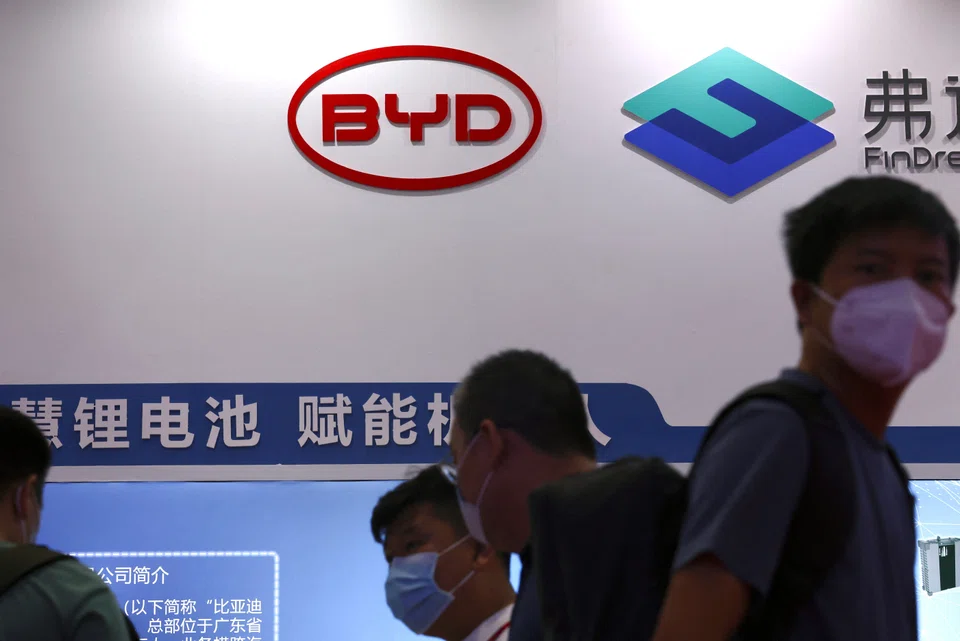 People walk past a booth of BYD's subsidiary FinDreams Battery, at the 2022 World Robot Conference in Beijing, China August 18, 2022. REUTERS/Tingshu Wang