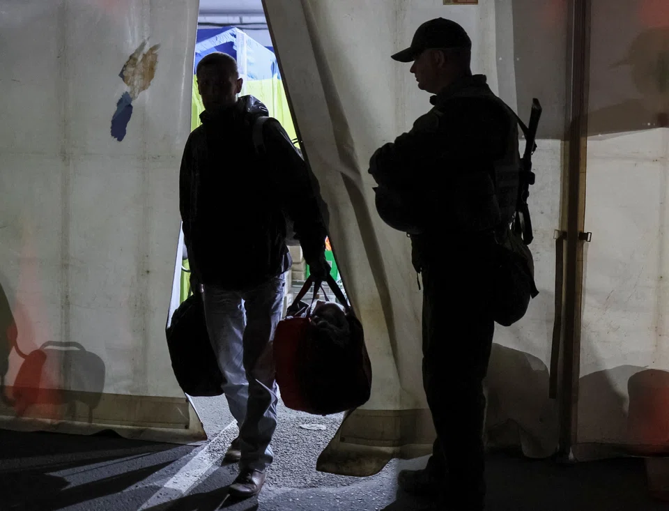 A Ukrainian police officer guards as refugees from the Azovstal steel plant in Mariupol arrive at a registration and humanitarian aid centre for internally displaced people, amid Russia's ongoing invasion of Ukraine, in Zaporizhzhia, Ukraine May 8, 2022. 