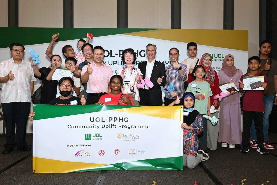 Guest of nonour Minister for National Development and Minister-in-charge of Social Services Integration Desmond Lee, UOL group chief executive Liam Wee Sin, PPHG executive director of sustainability partnerships Wee Wei Ling, and PPHG chief executive Choe Peng Sum with the ComLink children and their families at the launch of the UOL-PPHG Community Uplift Programme.