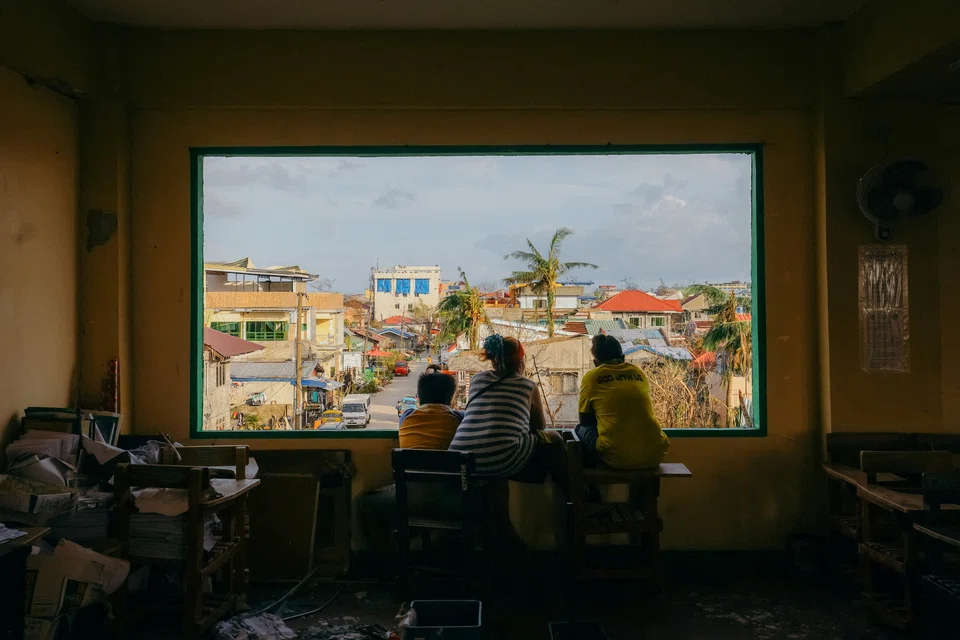 People look out from a window at an evacuation center following typhoon Rai, in Surigao City, Surigao del Norte, Philippines, Dec 21, 2021. 