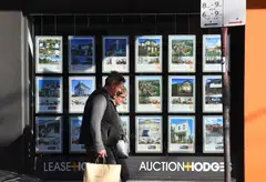 A real estate agent's window advertising houses for sale and auction in Melbourne, where prices fell 8.5 per cent this year.  