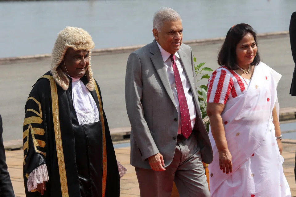 Sri Lankan President Ranil Wickremesinghe (C), accompanied by Speaker of the Parliament Mahinda Yapa Abeywardena (L), arrives at the parliament complex for the inauguration of the fifth session of the ninth Parliament in Colombo.