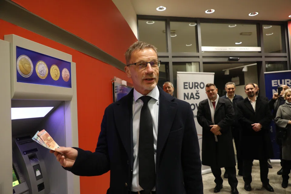 Croatian National Bank governor Boris Vujcic taking the first euro banknotes at an ATM in Zagreb, Croatia on Jan 1.