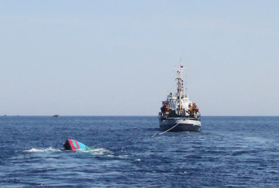 A Vietnamese sinking boat (left) which was rammed and then sunk by Chinese vessels near disputed Paracels Islands, is seen near a Marine Guard ship (right) at Ly Son island of Vietnam's central Quang Ngai province, May 29, 2014. 