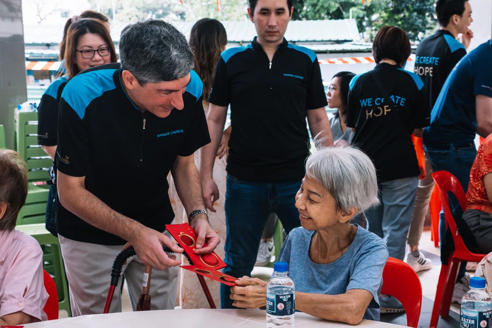 Nicholas Ionides, MBS’ vice-president of communications and corporate affairs, with a senior at the reunion lunch organised by MBS and Care Corner.