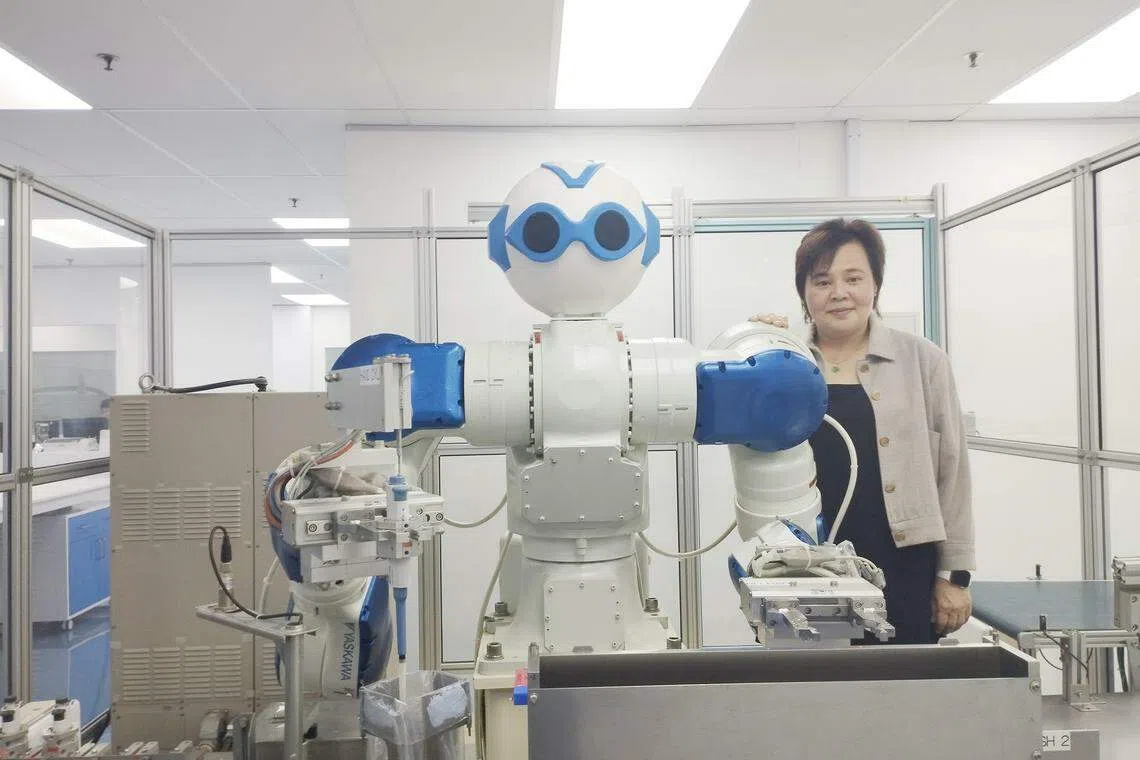 Eunice Ng with Miss Ugene, the company's first robot that was introduced in 2014. 