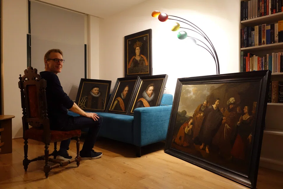 Dutch art detective Arthur Brand, posing next to six paintings he has recovered, including a portrait of William of Orange and the first depiction of a seventh-century king. 