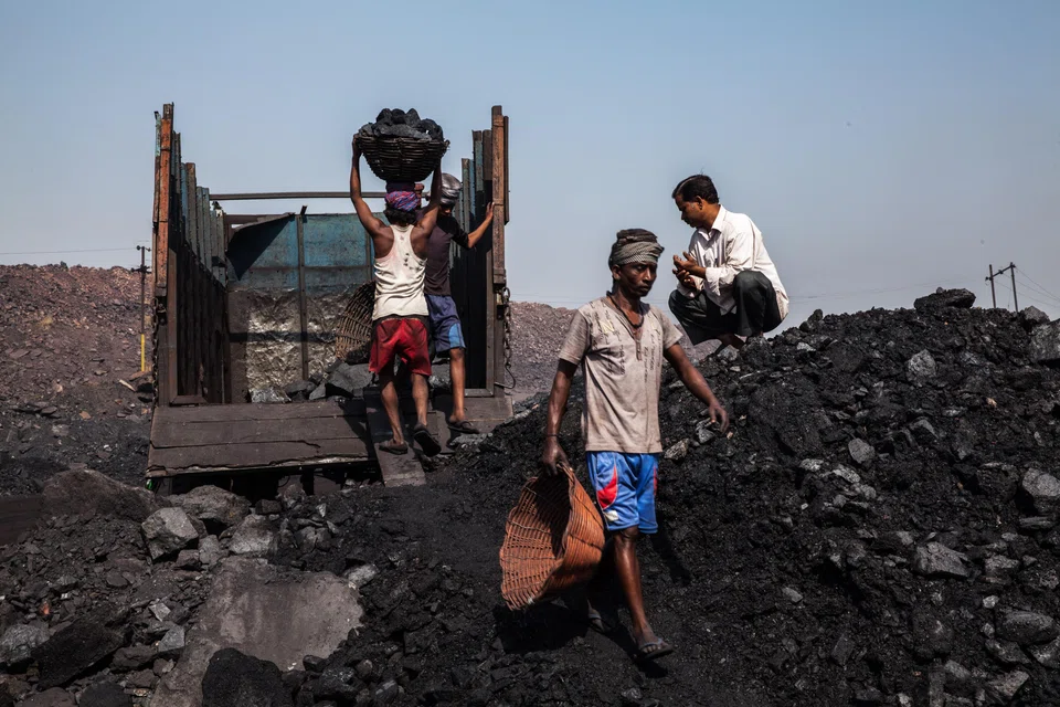 Day labourers loading coal into trucks at a coal mine in Jharkhand, India.   