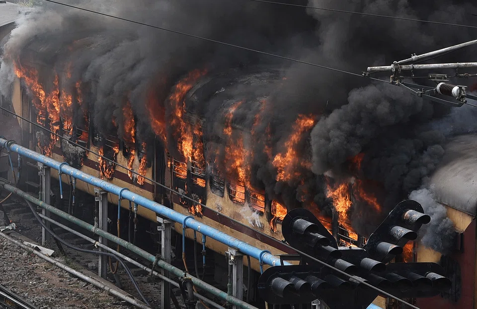 Smoke billows out from a passenger train coach after it was set on fire by protestors during a protest against "Agnipath scheme" for recruiting personnel for armed forces, in Secunderabad in the southern state of Andhra Pradesh.