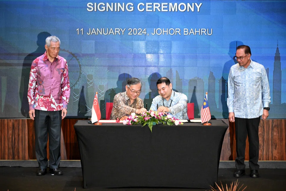 Singapore's Minister for Trade and Industry Gan Kim Yong (centre left) and Malaysia's Minister of Economy Mohd Rafizi Ramli (centre right) signing a memorandum of understanding on Thursday to work on the Johor-Singapore Special Economic Zone. Singapore Prime Minister Lee Hsien Loong (far left) and Malaysian Prime Minister Anwar Ibrahim (far right) witness the signing.