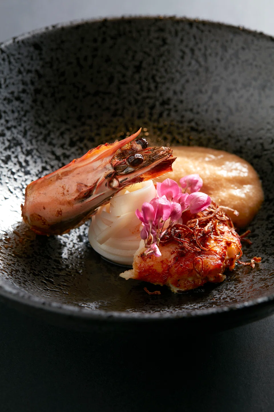 Squid noodles in lobster bisque espuma and tiger prawn.