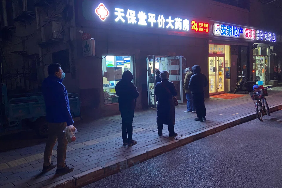 People queuing to buy medicine at a pharmacy in Beijing, and analysts are warning that China is ill-prepared for a wave of infections that could impact its fragile health system and grind businesses to a halt.