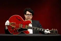 Guitar expert Arthur Perrault holds the Oasis band member Noel Gallagher's Gibson ES-355 guitar, destroyed during an argument with his brother at Paris' Rock en Seine festival in 2009, at a media preview in Paris, France May 13, 2022. 