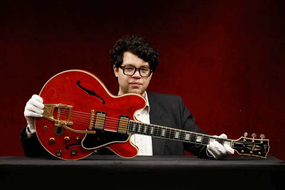 Guitar expert Arthur Perrault holds the Oasis band member Noel Gallagher's Gibson ES-355 guitar, destroyed during an argument with his brother at Paris' Rock en Seine festival in 2009, at a media preview in Paris, France May 13, 2022. 