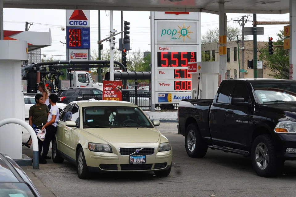 Customers at a petrol station on May 10, 2022 in Chicago, Illinois. US crude oil price settled below US$100 a barrel on Tuesday.
