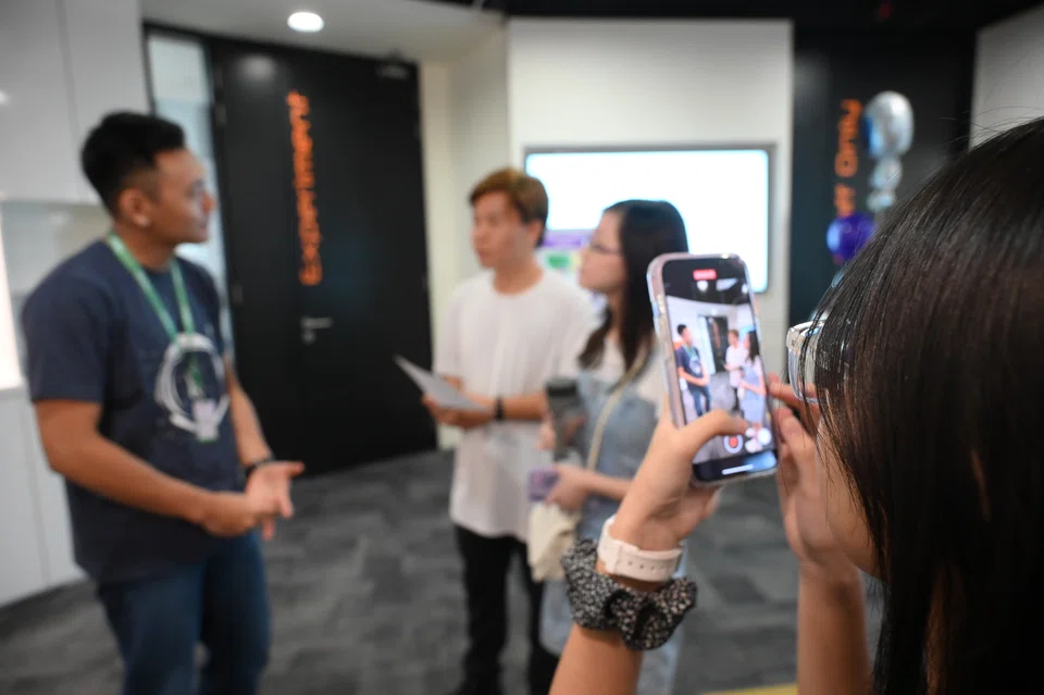 Participants filming a mock street interview during a Thrive workshop at the World X 2023 career fair on Jul 22.