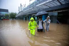 People wade through flood waters at the Shenzhen Bus Station in Shenzhen, in China's Guangdong province on Sept 8, 2023, after the city recorded the heaviest rains since records began in 1952. 