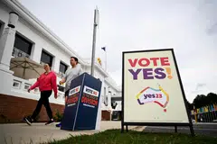Voters walk past Vote 'Yes' and Vote 'No' signs at the Old Australian Parliament House, during The Voice referendum in Canberra, Australia on Oct 14. 