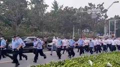 Uniformed and plain-clothed security personnel approaching demonstrators outside a People's Bank of China building in Zhengzhou, Henan province, in a screen grab from a video.
