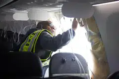 A National Transportation Safety Board investigator examining the fuselage plug area of Alaska Airlines Flight 1282 Boeing 737-9 MAX.
