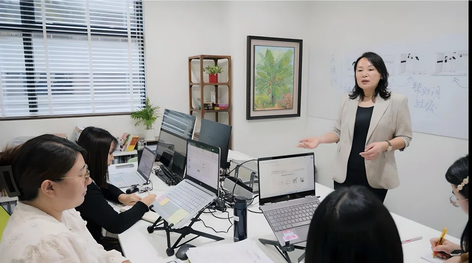 Wang Learning Centre’s founder and principal Wang Jie (standing) conducting a curriculum discussion. Developing proprietary teaching materials and pedagogy is one way that the centre sets itself apart.